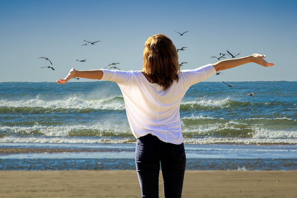 woman with arms wide on beach